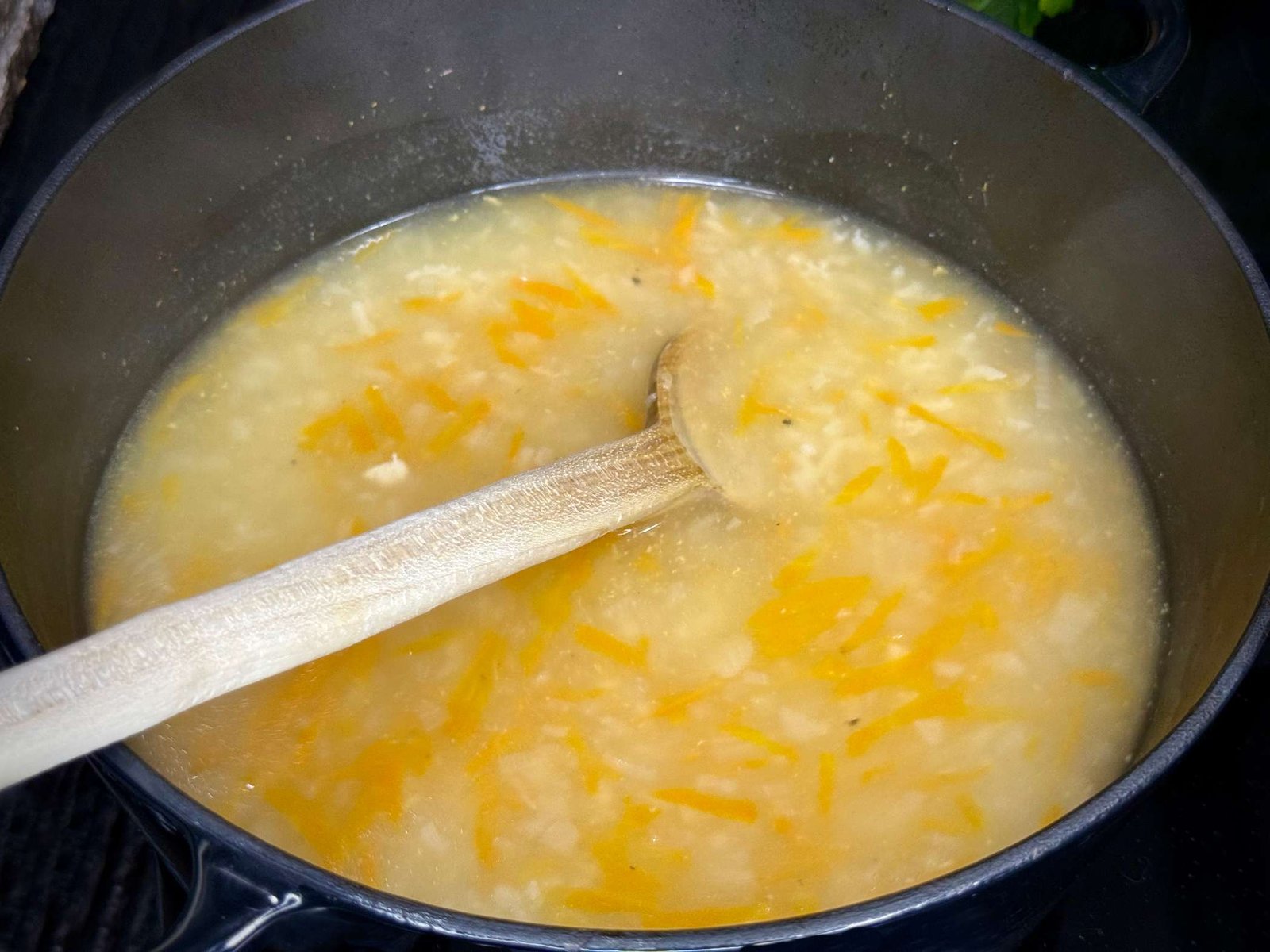 Korak dodavanja riže u avgolemono supu u toku kuhanja.