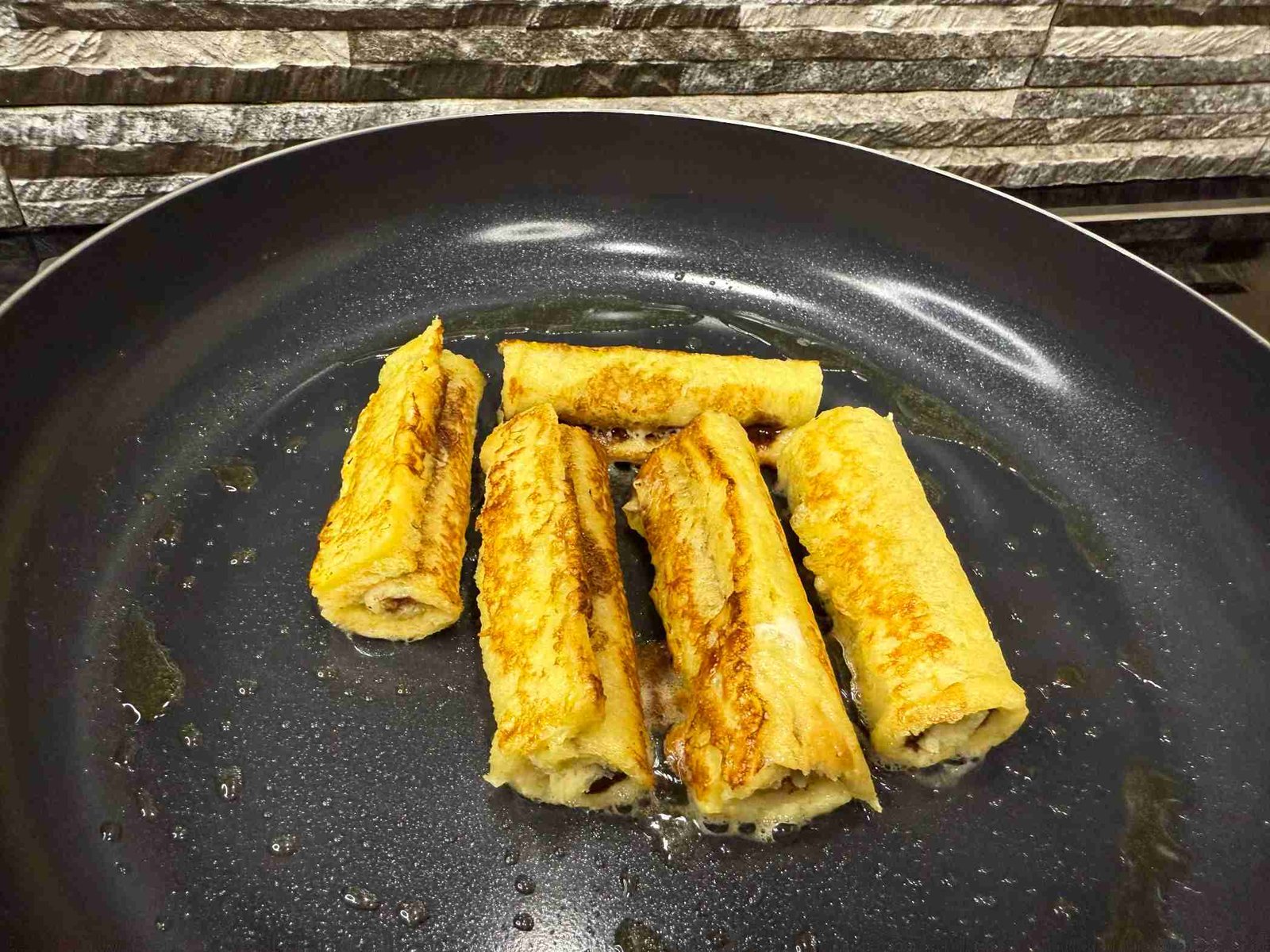 Pečenje rolnica francuskog tosta na maslacu.