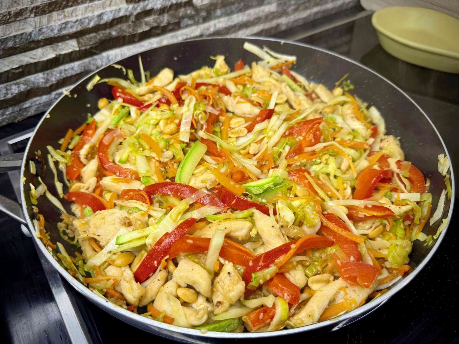 Piletina sa kikirikijem i povrćem spremljena na kineski način u wok tavi.