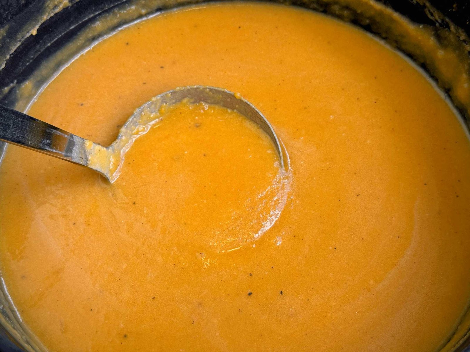 krem-supa-od-bundeve-u-loncu Gusta i kremasta supa od bundeve nakon blendanja, prikazana u loncu sa kutlačom.