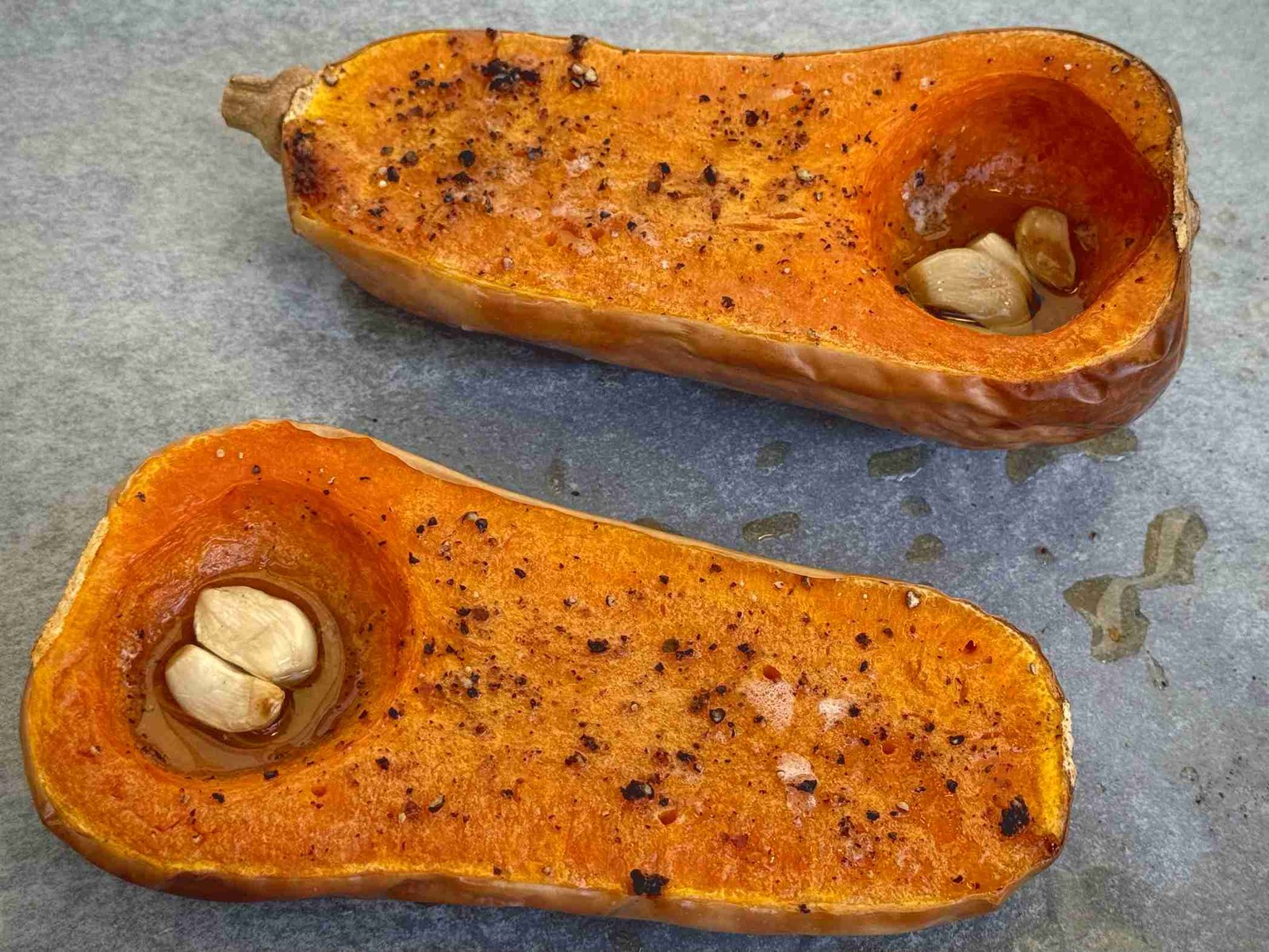 pecenje-bundeve-za-supu-u-rerni Polovine muskatne bundeve sa bijelim lukom pečene u rerni do karamelizacije.