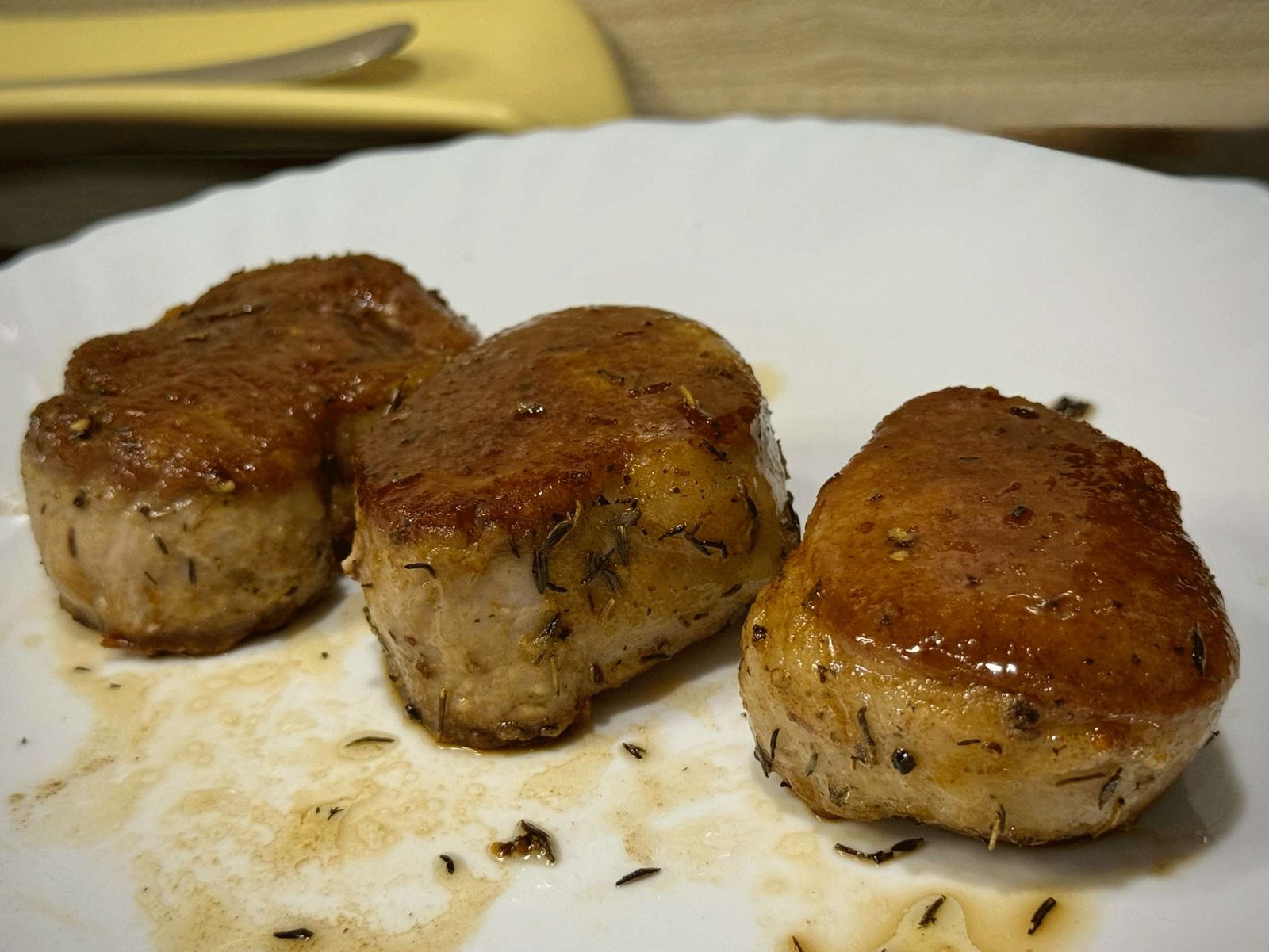 svinjsi-file-medaljoni Tri sočna medaljona svinjskog filea, savršeno pečena basting tehnikom, sa hrskavom koricom i majčinom dušicom, spremni za odmaranje.