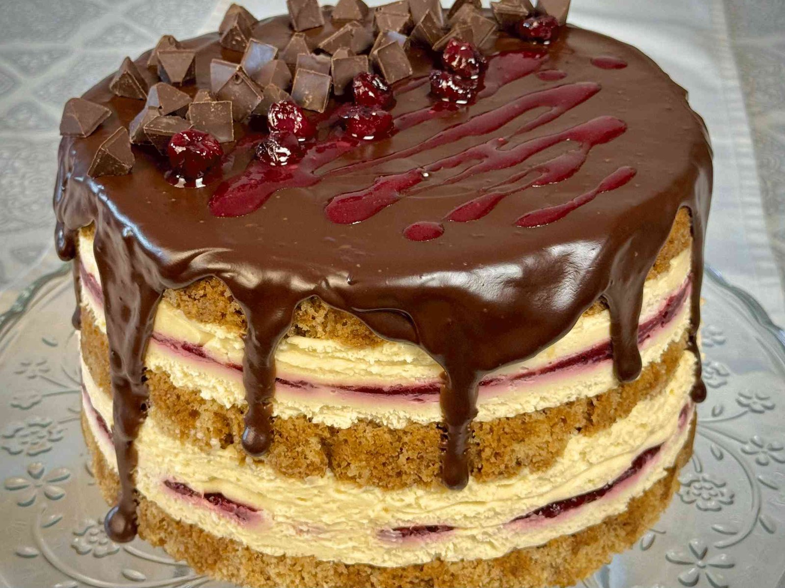 Troetažna Moka Amarena torta sa sočnim korama od oraha, mascarpone filom, filom od višanja i bogatom čokoladnom glazurom koja curi.