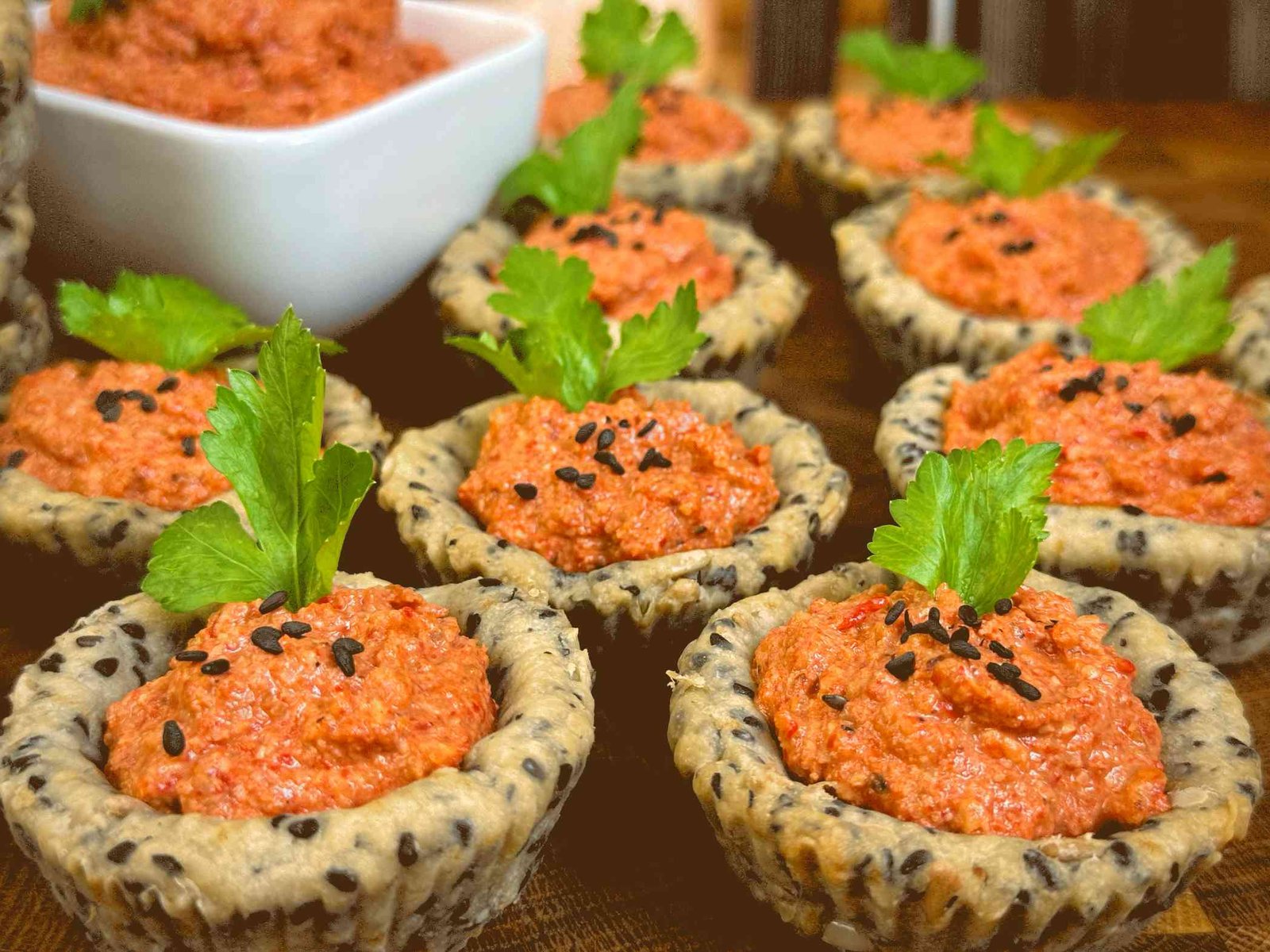 Hrskave posne korpice punjene kremastim filom od pečene paprike i oraha, ukrašene crnim susamom.