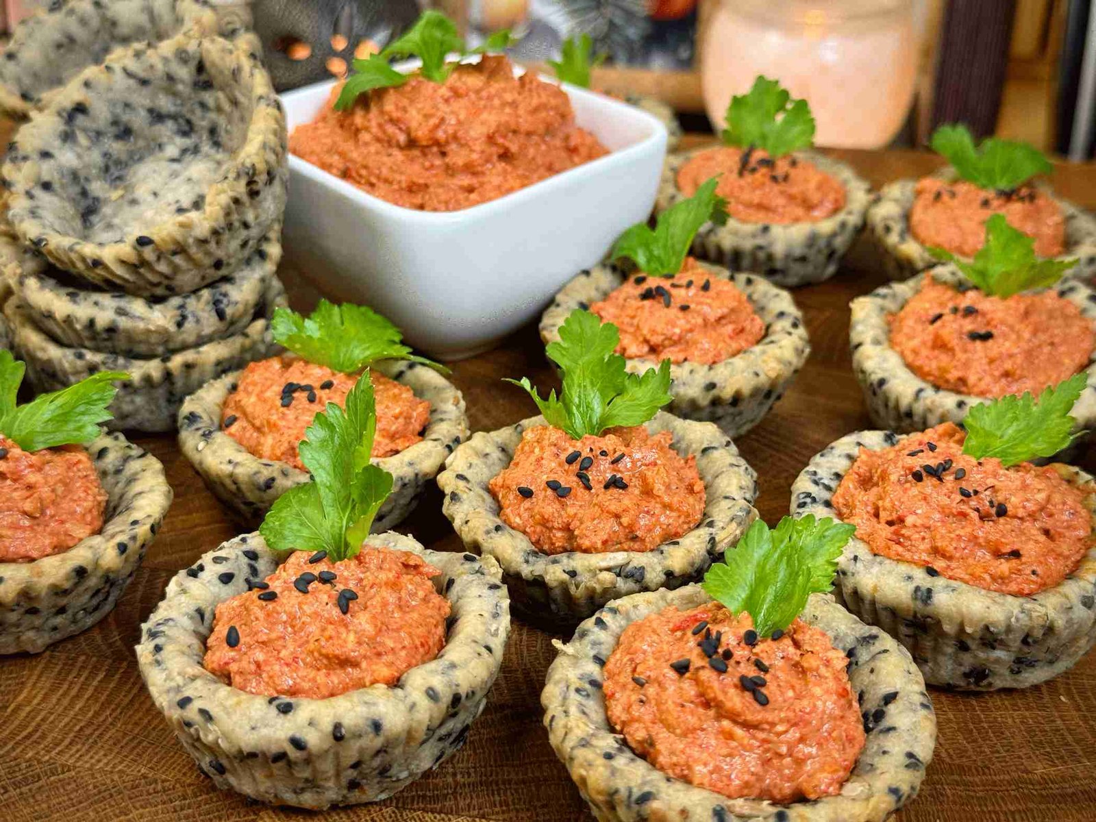 Grupno serviranje punjenih posnih korpica sa filom, ukrašenih peršunom i crnim susamom, uz činiju fila u pozadini.