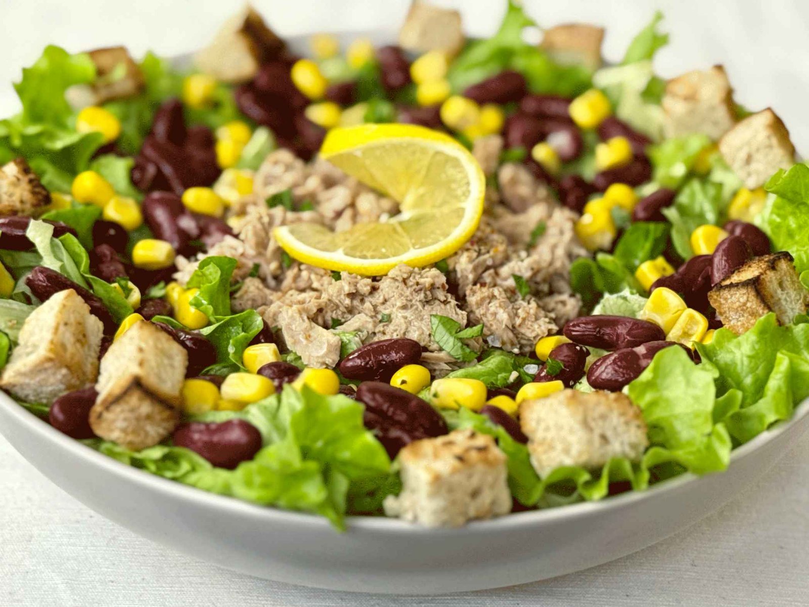 Posna tuna salata sa crvenim grahom, kukuruzom i zelenom salatom u plitkoj zdjeli, svježa i zasitna.