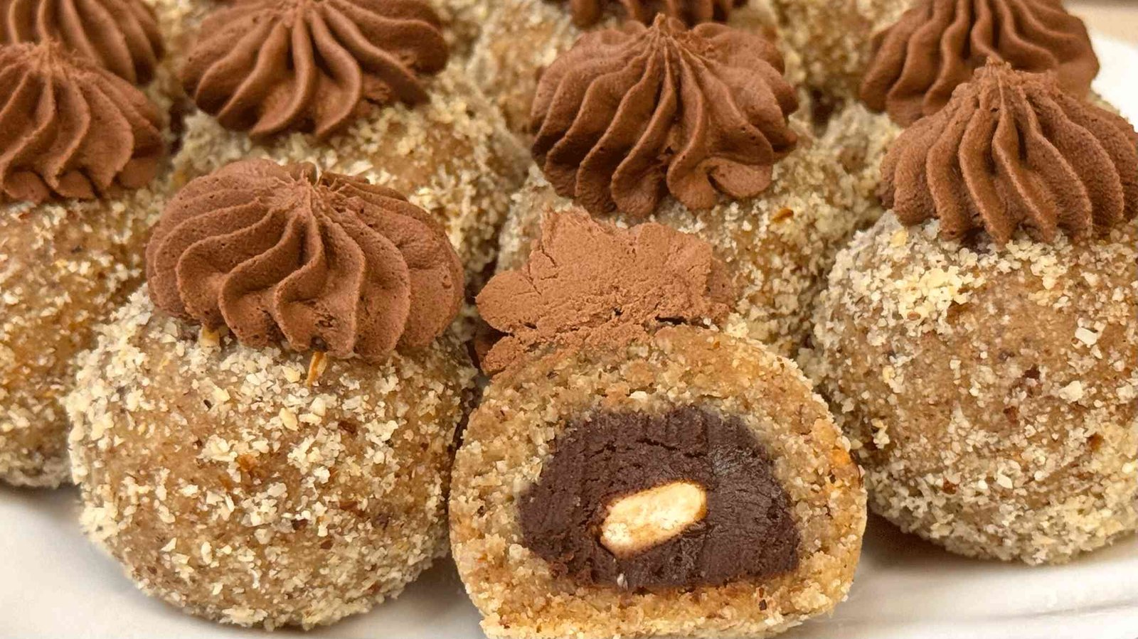 Presjek posne Ferrero praline gdje se vidi bogato čokoladno srce i cijeli lješnjak u sredini.