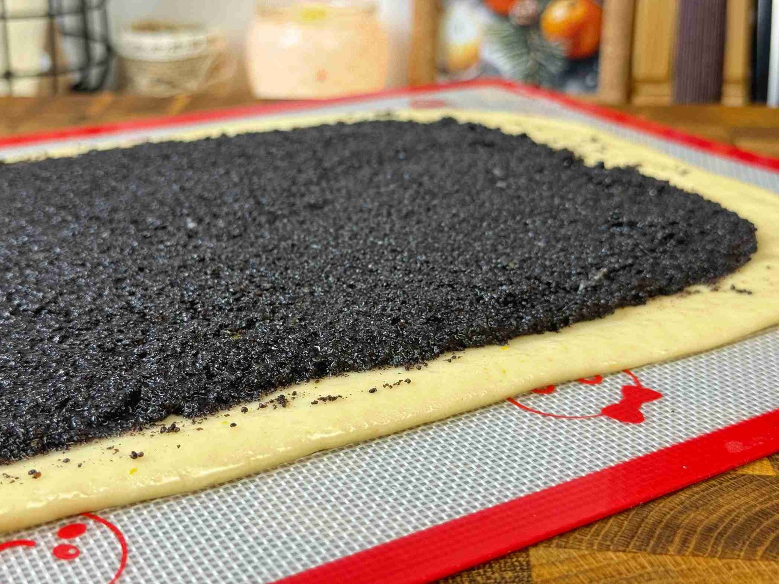 Razvijeno tijesto posuto filom od maka i džema, spremno za motanje