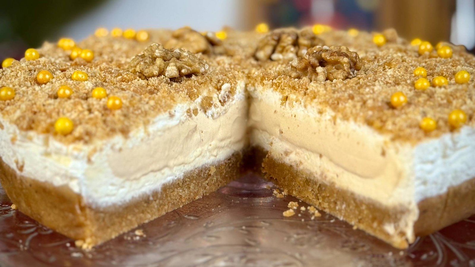 Krupni kadar presjeka Medena Plazma kolača sa vidljivim slojevima baze od plazme i oraha, bijelog maskarpone fila i bogatog karamel jezgra.