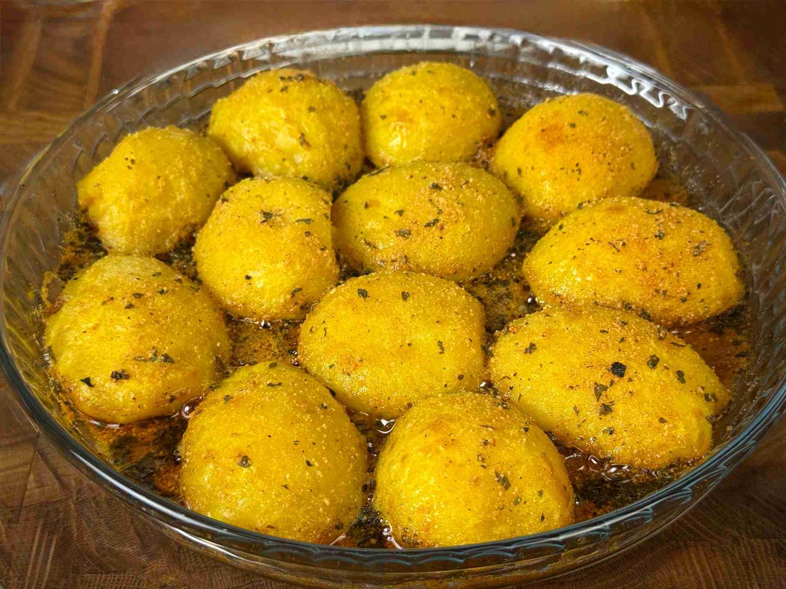 peceni-krompir-sa-parmezanom Pečeni krompir sa parmezanom zlatno-žute boje serviran u staklenom plehu.