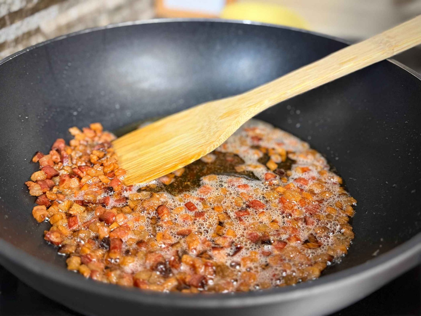 hrskava-slanina-amatriciana Sjeckana slanina koja se lagano prži u tavi do zlatno-smeđe boje i hrskave teksture.