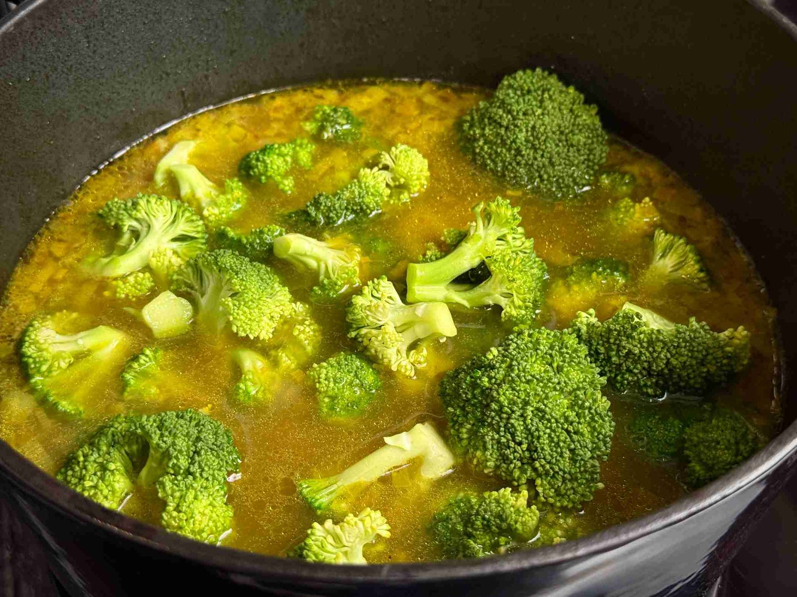 kuhani-brokoli-u-corbi Svježi zeleni cvjetovi brokule u šerpi sa povrtnim temeljcem i kurkumom.