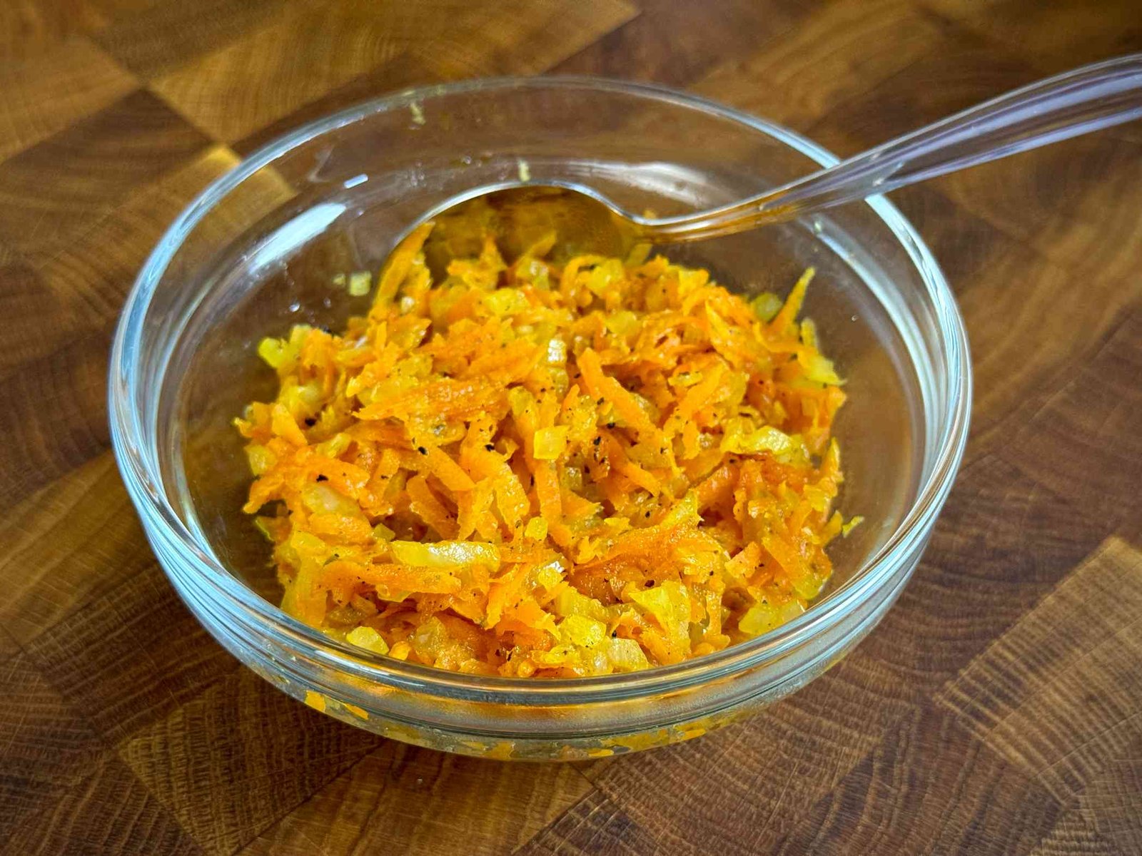 Ispržena rendana mrkva i sitno sjeckani luk u staklenoj činijici, spremni za punjenje ribe.