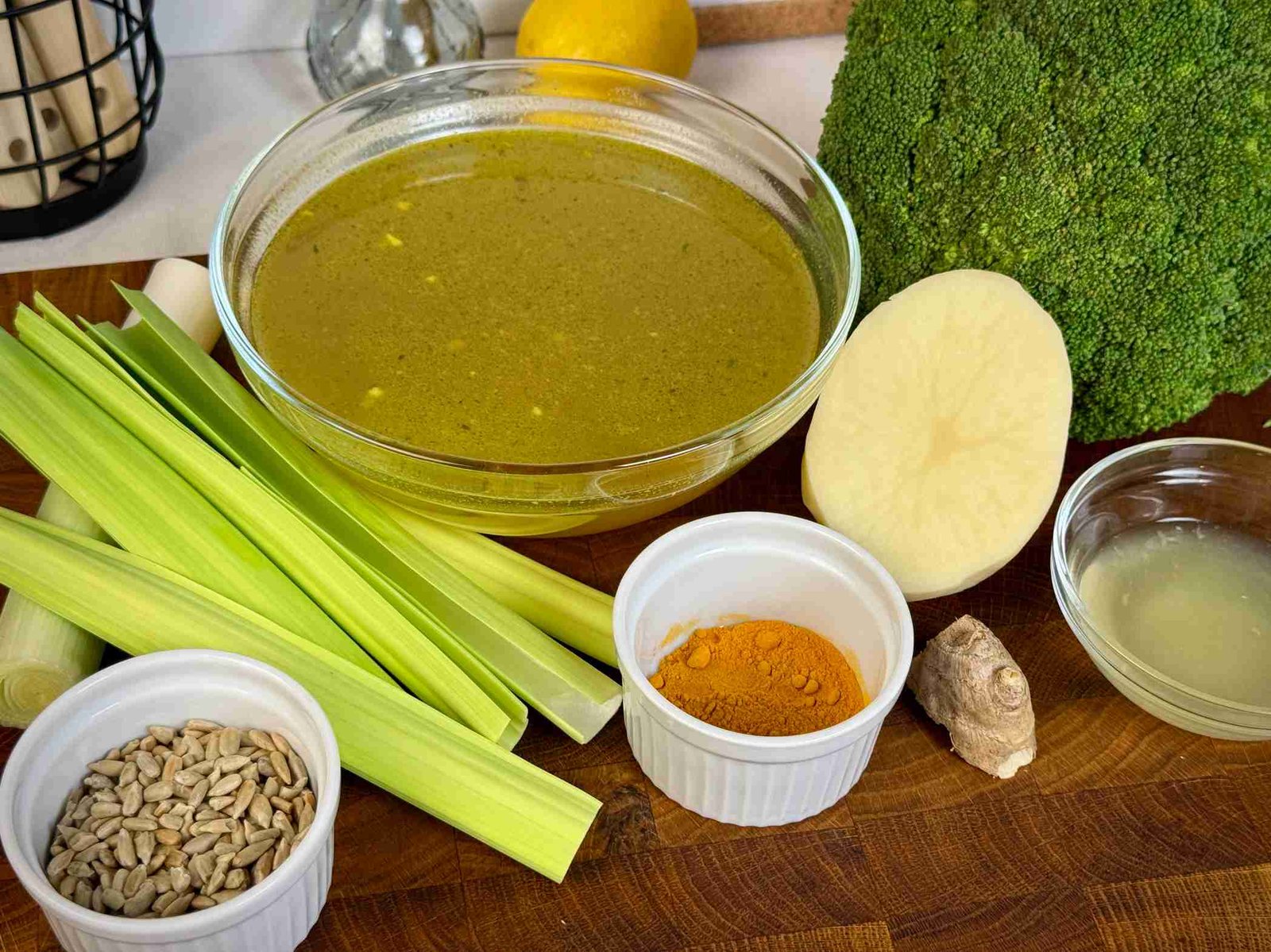 sastojci-za-supu-od-brokolija Svježa glavica brokule, korijen đumbira, praziluk, krompir, povrtni temeljac i začini pripremljeni za zdravu čorbu od brokolija.