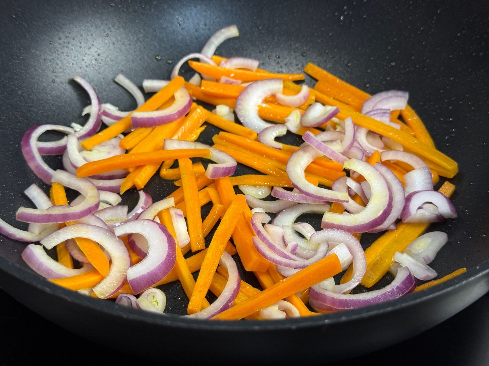 Luk i mrkva se prže u wok tavi