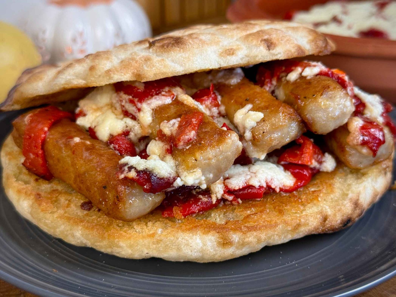 cevapi-sa-kajmakom-i-pecenom-paprikom-u-lepinji Sočni ćevapi sa kajmakom i pečenom crvenom paprikom, posluženi u hrskavoj lepinji.